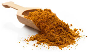 Ras El Hanout spices in a serving scoop. 
Isolated on a white background.